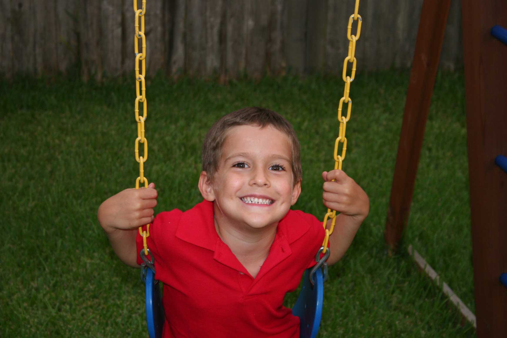 Boy with beautiful smile on swing